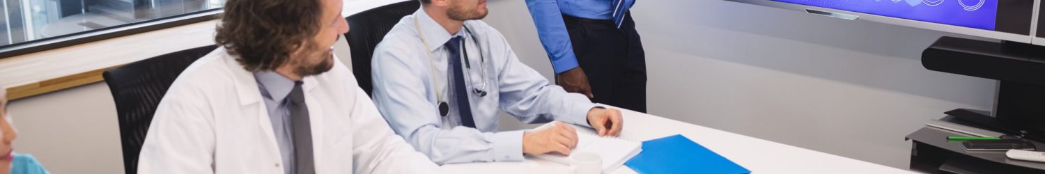 Doctor giving presentation to team of interim doctors at conference room